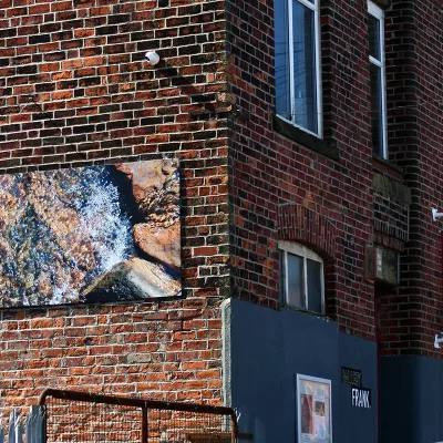 Ebor Studio: red brick building with billboard detailing a riverbed