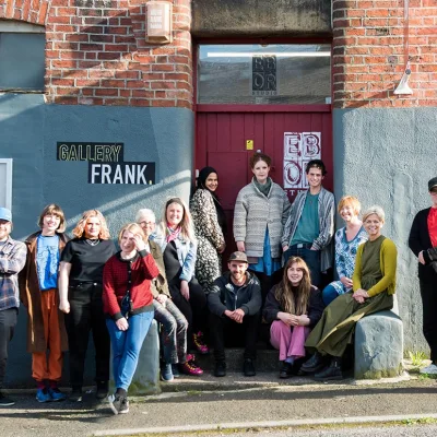 Ebor Studio: Group photo of smiling people in front of red brick and grey plaster building